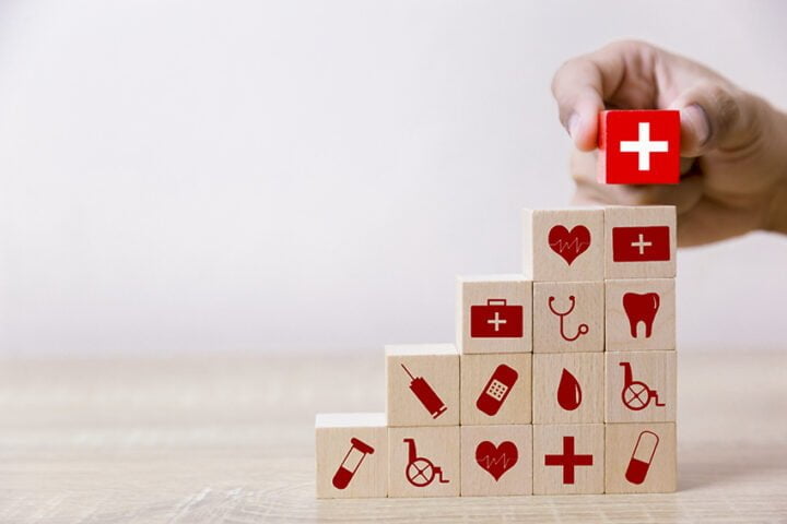 Health Insurance Concept,hand arranging wood block stacking with