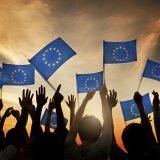 Group of People Waving European Union Flags in Back Lit