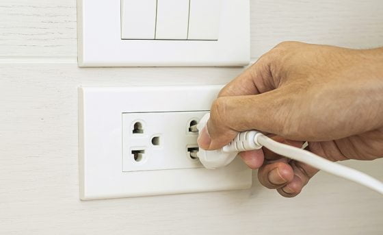 Closeup Male finger unplugging or plugging of electricity device