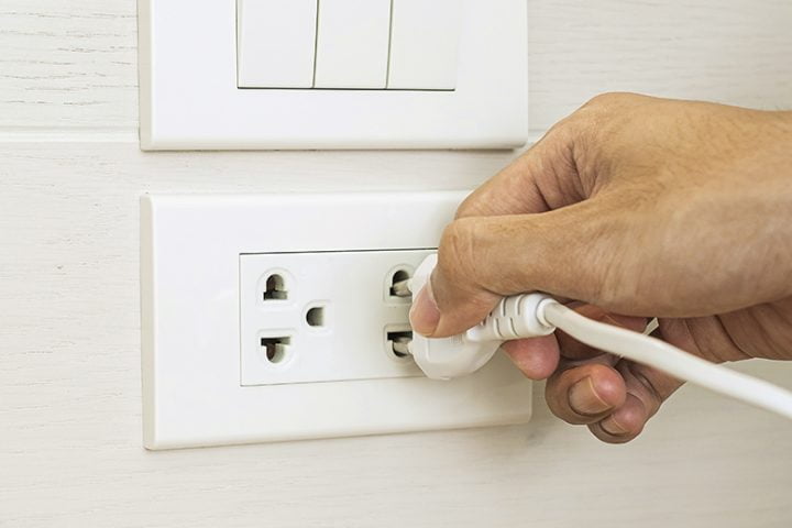 Closeup Male finger unplugging or plugging of electricity device