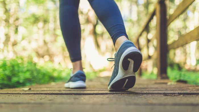 Close up of female legs with running shoes on wooden footpath in