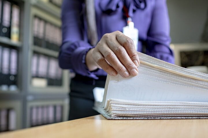 The hand of a woman holds important documents in the office.