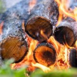 Close up of brightly burning wooden logs with yellow hot flames