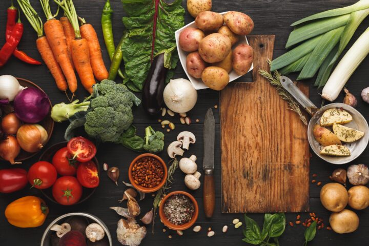 Fresh organic vegetables on wood background.
