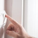 Hand turning off on light switch.