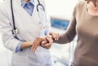 General practitioner is holding female hand in the hospital