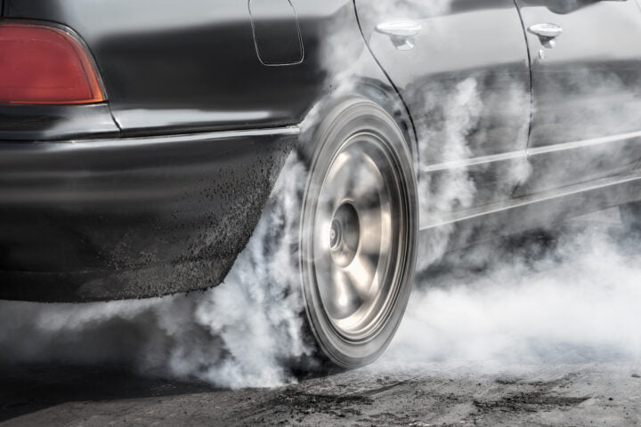 Drag racing car burns rubber off its tires in preparation for th