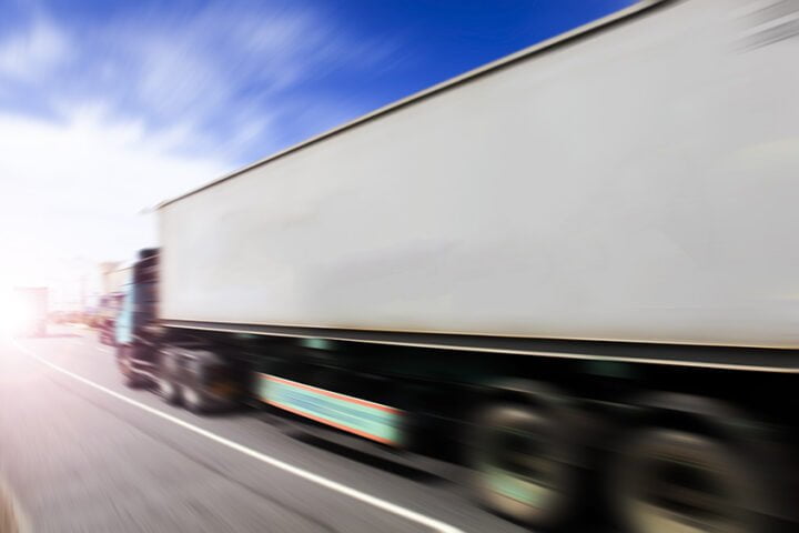 Generic big trucks speeding on the highway at sunset - Transport industry concept , big truck containers