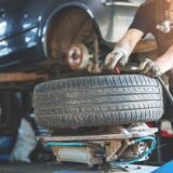 mechanic fixing tire at car repair service