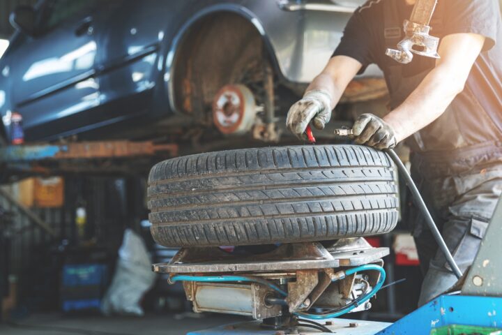 mechanic fixing tire at car repair service