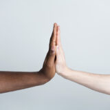 Closeup photo of two arms clap giving five different race multinational relationship antiracism issue help together world globe partners immigration integration isolated grey color background