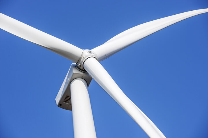 Wind turbines generating electricity with blue sky. Close up of