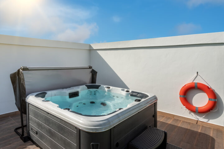 Luxury bathtub, jacuzzi for therapeutic massage and relaxation outside on the grass. Under the blue sky.