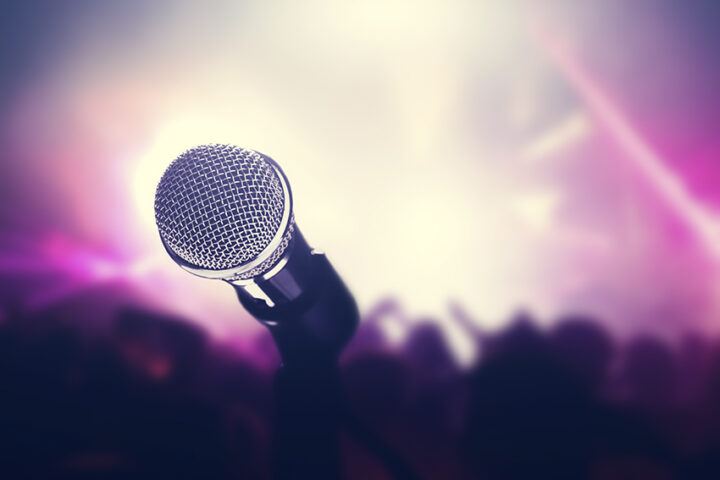 Microphone on stage, crowd of people in the club.