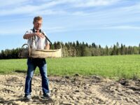 Maatalousyrittäjä Pertti Lind heitteli siunattua viljaa peltoon Heikkisenahossa kesän aluksi toukosiunauksessa.