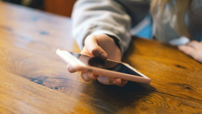 A young girl in a cafe uses the phone.