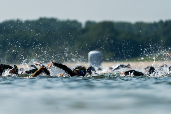 Triathletes swimming in a lake at a triathlon competition