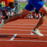legs male athlete start running in starting blocks sprint race, summer athletics championships