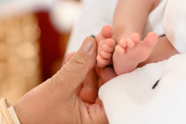 The priest performs the rite of baptism of the child and anoints the leg with holy peace.