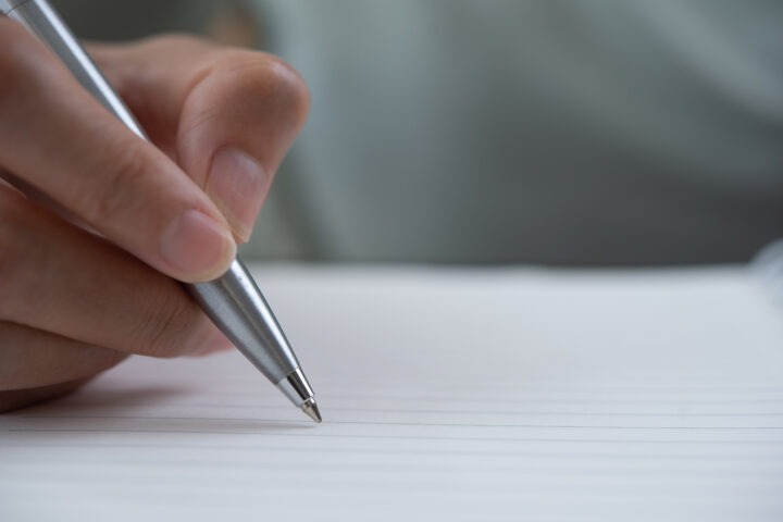 Close up of business woman hand with a pen writing note on spira