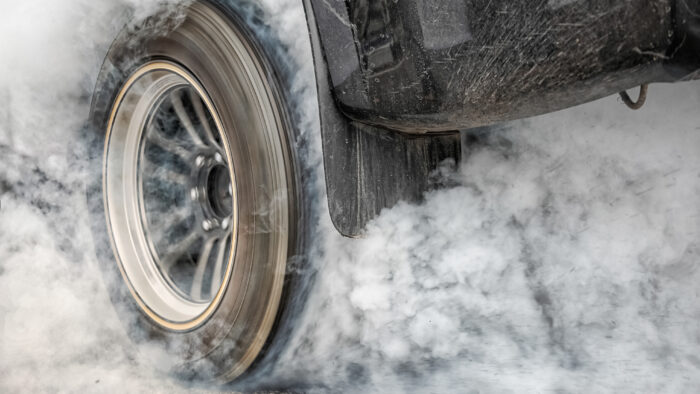 Drag racing car burns rubber off its tires in preparation for the race